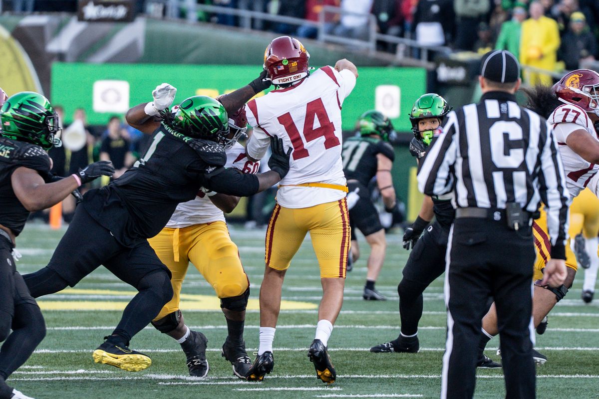 USC Trojans quarterback , Jayden Maiava (14) throws a pass in the middle while have his helmet slapped during an NCAAF football game against the Oregon Ducks on November 22, 2025 in Eugene, OR.