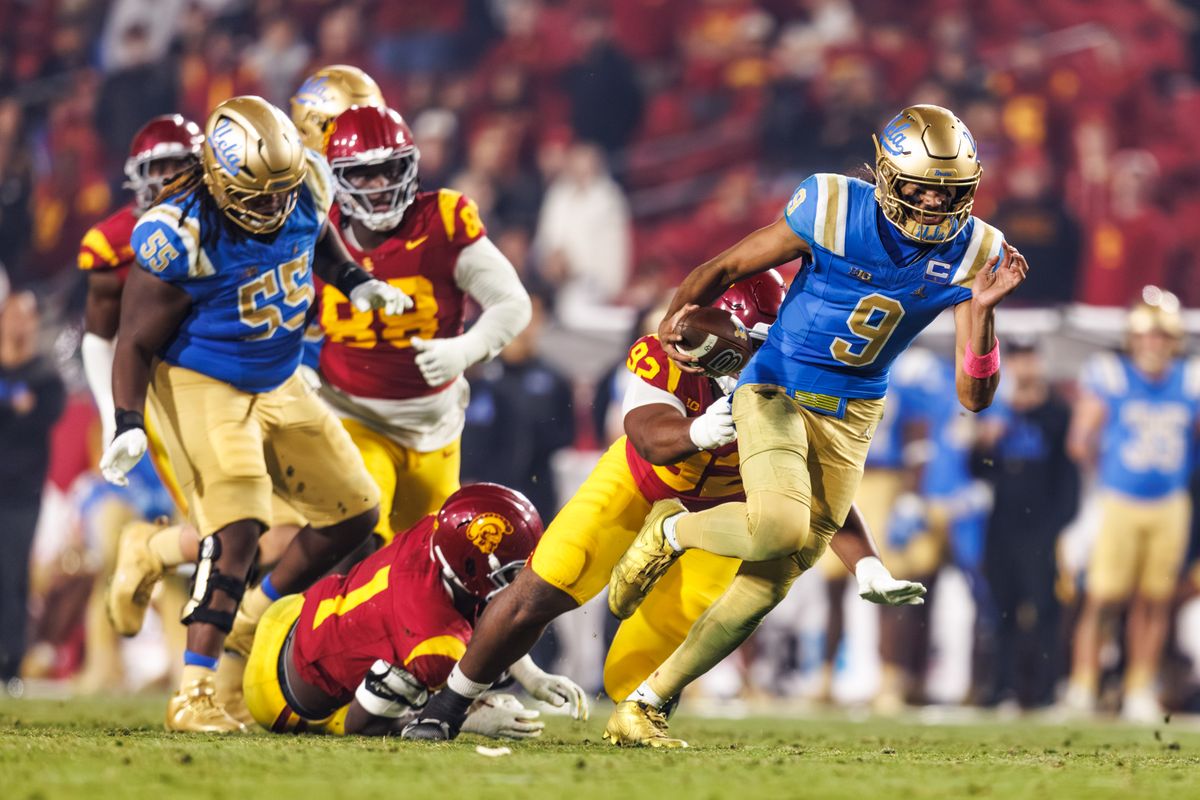 UCLA Bruins quarterback Nico Iamaleava (9) runs the ball while getting pulled down during a NCAAF game against the Southern California Trojans on November 29, 2025 in Los Angeles, CA.