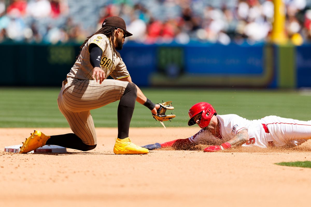 Zach Neto #9 of the Los Angeles Angels slides into second base against Fernando Tatis Jr. #23 of the San Diego Padres during the game at Angel Stadium of Anaheim on April 19, 2026 in Anaheim, California.