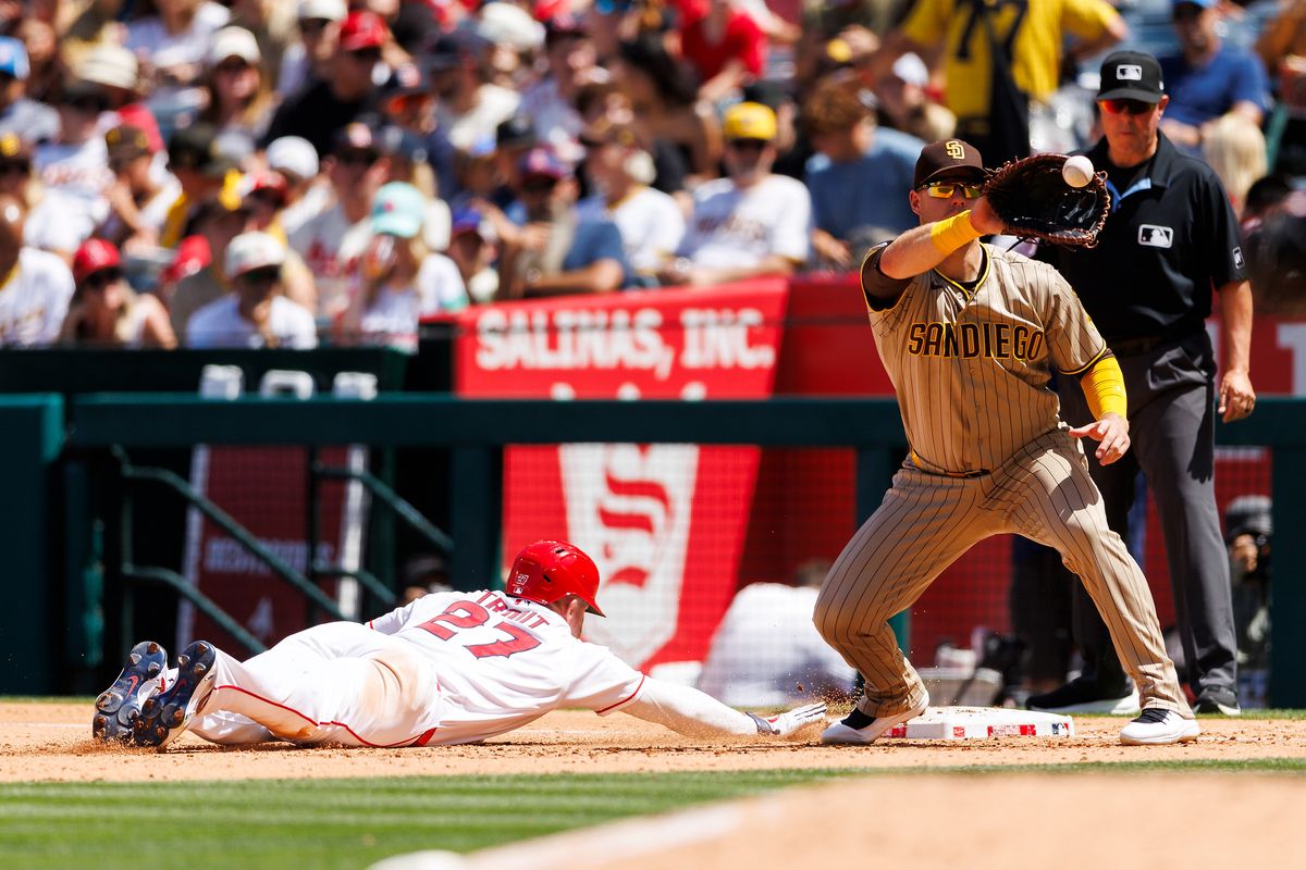 Mike Trout #27 of the Los Angeles Angels dives back to first base against Gavin Sheets #30 of the San Diego Padres during the game at Angel Stadium of Anaheim on April 19, 2026 in Anaheim, California. 