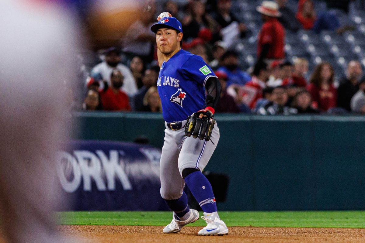 Kazuma Okamoto #7 of the Toronto Blue Jays prepares to throw the ball to first base during an MLB game against the Los Angeles Angels at Angel Stadium on April 21, 2026 in Anaheim, California.