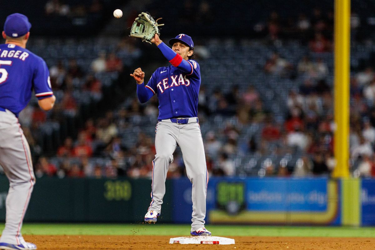 Nicky Lopez #33 of the Texas Rangers attempts to complete a double play during an MLB game against the Los Angeles Angels on August 12, 2026 at Angel Stadium in Anaheim, California.