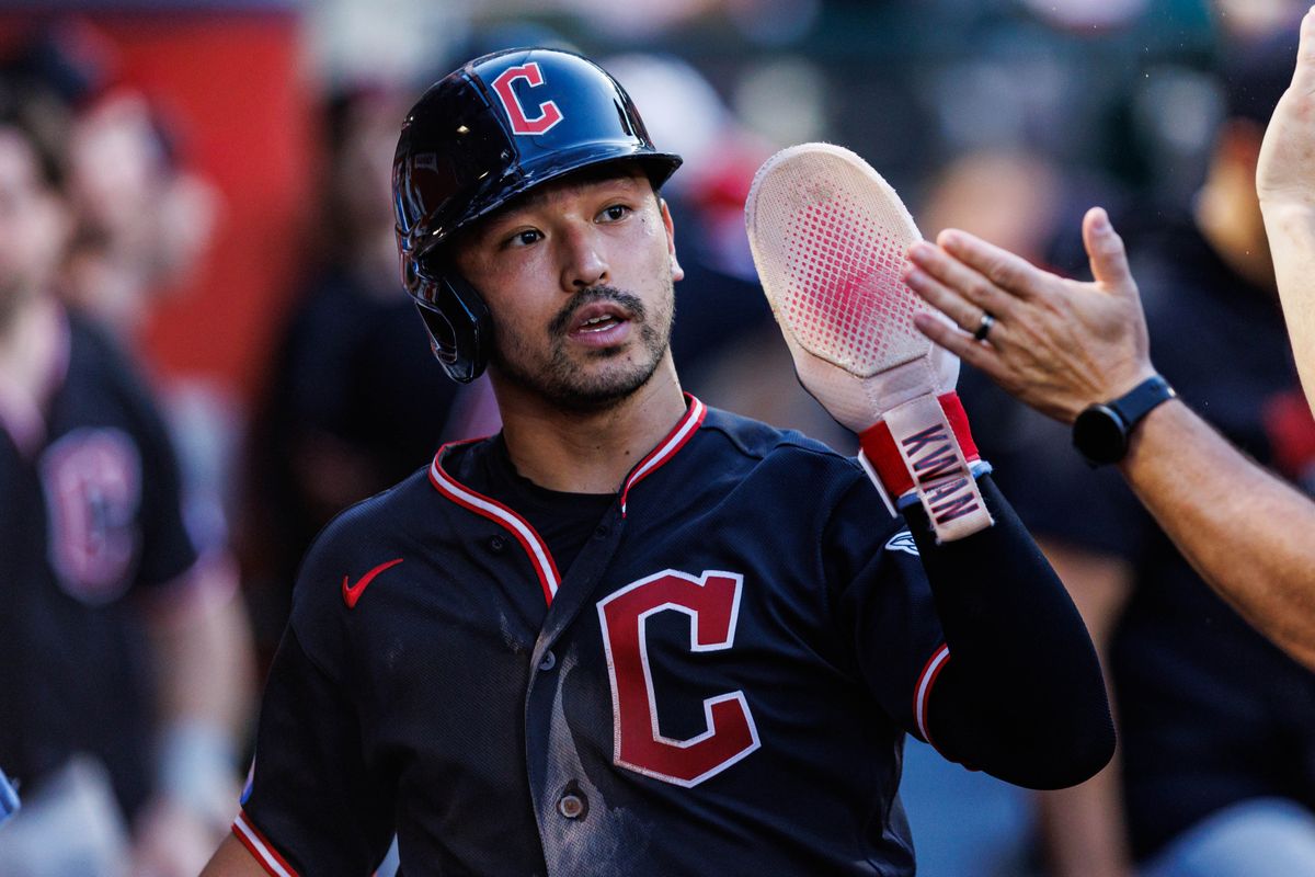 Steven Kwan #38 of the Cleveland Guardians is welcomed after scoring a run during an MLB game against the Los Angeles Angels on August 24, 2026 at Angel Stadium in Anaheim, California.