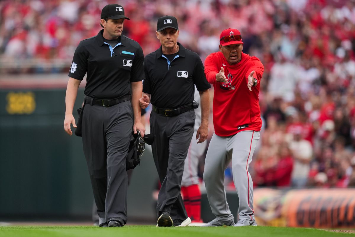 Los Angeles Angels manager Kurt Suzuki, right, reacts after being ejected from the game by umpire Adam Beck, left, as Dan Iassogna, middle, assist during the game against the Cincinnati Reds in the eighth inning at Great American Ball Park. Los Angeles Angels manager Kurt Suzuki, right, reacts after being ejected from the game by umpire Adam Beck, left, as Dan Iassogna, middle, assist during the game against the Cincinnati Reds in the eighth inning at Great American Ball Park.