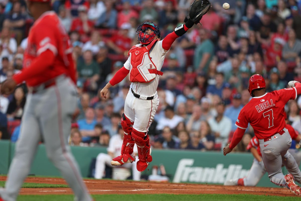 Los Angeles Angels center fielder Jo Adell (7) slides past Boston Red Sox catcher Connor Wong (12) during the third inning at Fenway Park.