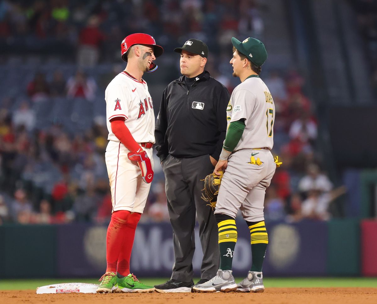 Los Angeles Angels infielder #9 Zach Neto and Las Vegas Athletics infielder #17 Luis Urias talk during a pause in action in Anaheim, CA.