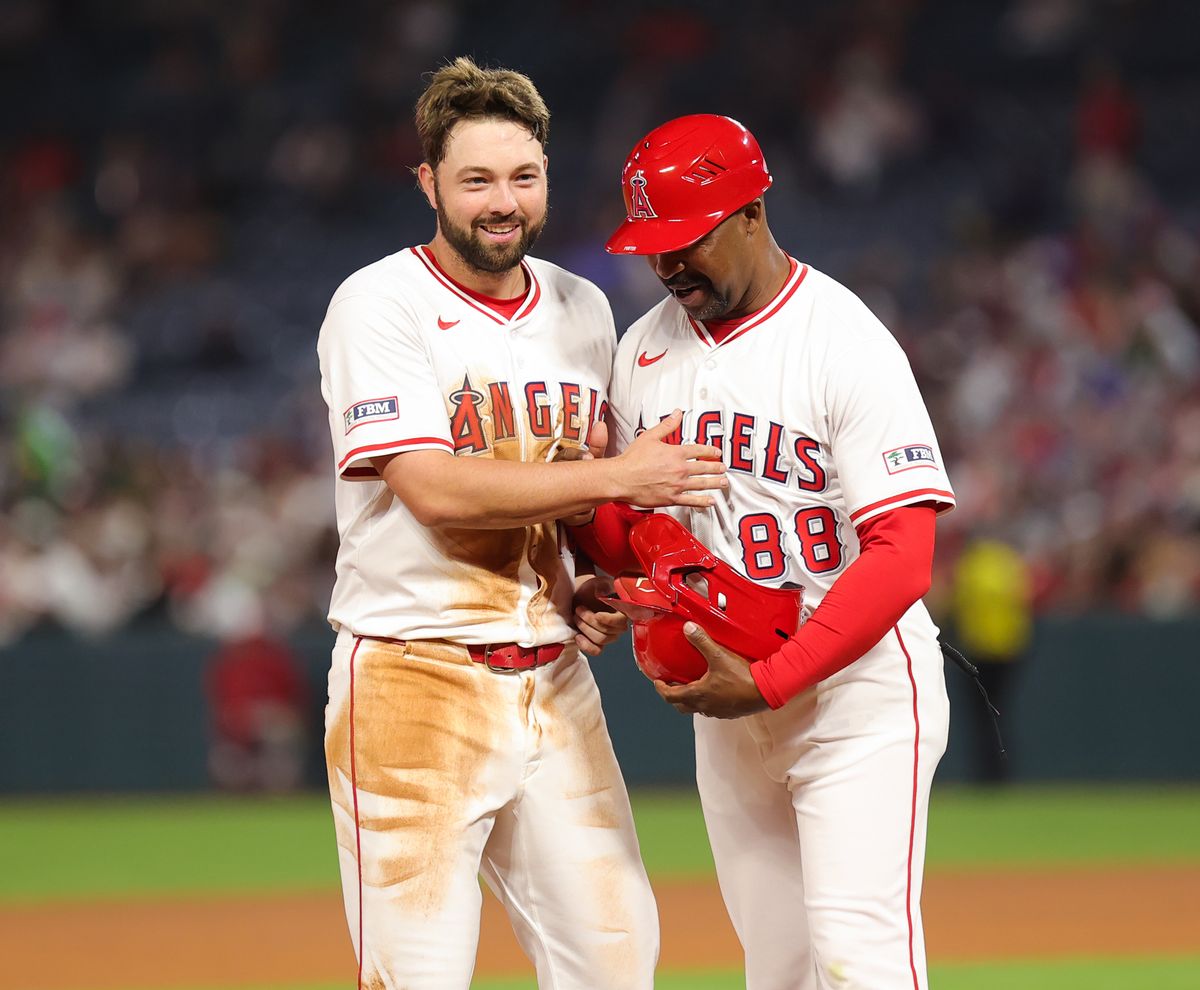 Los Angeles Angels infielder #18 Nolan Schanuel and thrid base caoch Bo Porter embrace each other during an MLB game against the Las Vegas Athletics on June 10, 2025 in Anaheim, CA.