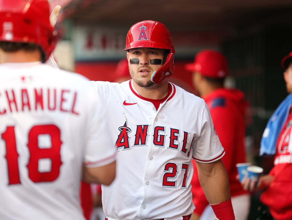 Los Angeles Angels outfielder #27 Mike Trout celebrates scoring a run in the dugout during an MLB game against the Houston Astros on June 21, 2025 in Anaheim, CA.