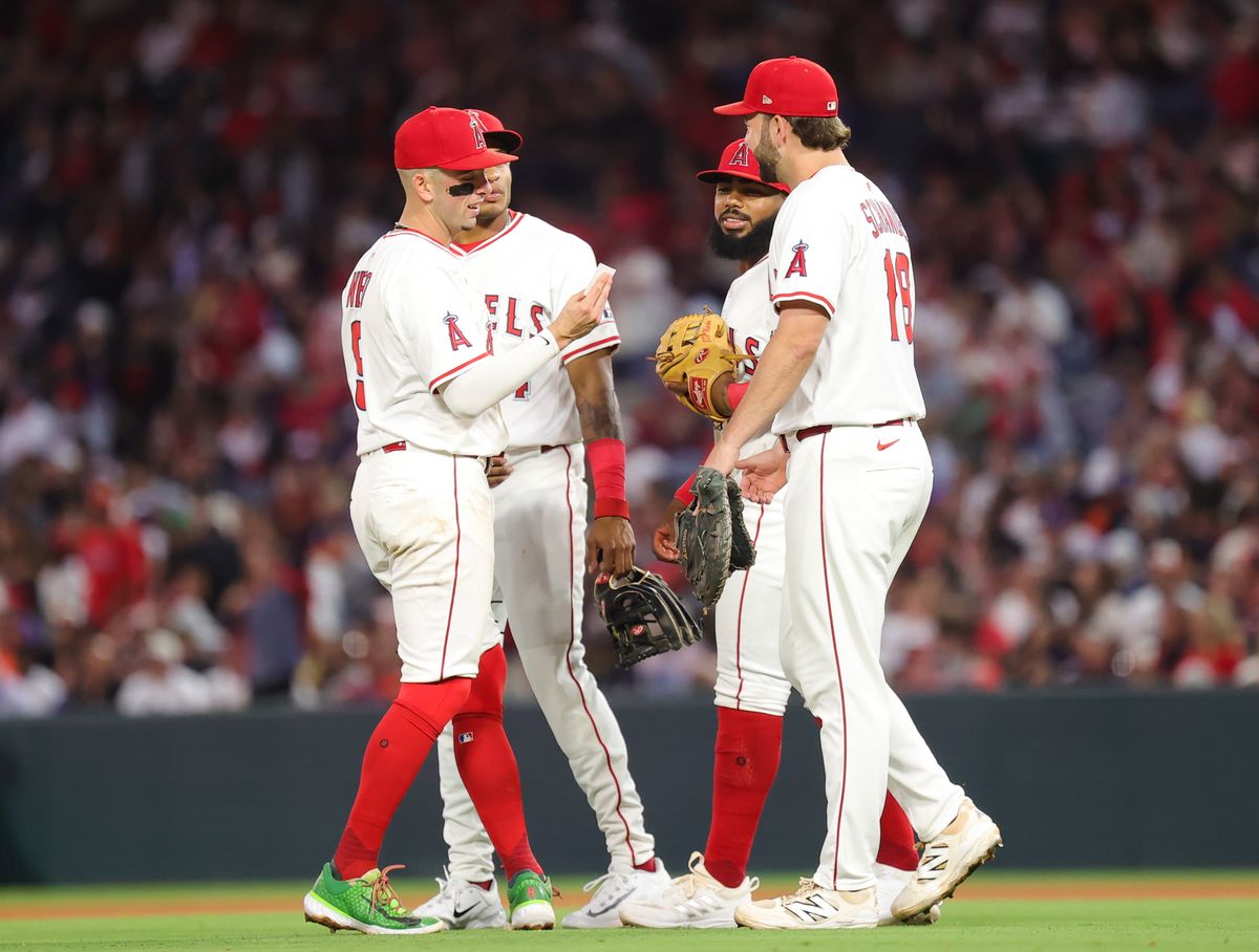 Los Angeles Angels player discuss strategy during a pause in action during an MLB game against the Houston Astros on June 21, 2025 in Anaheim, CA.