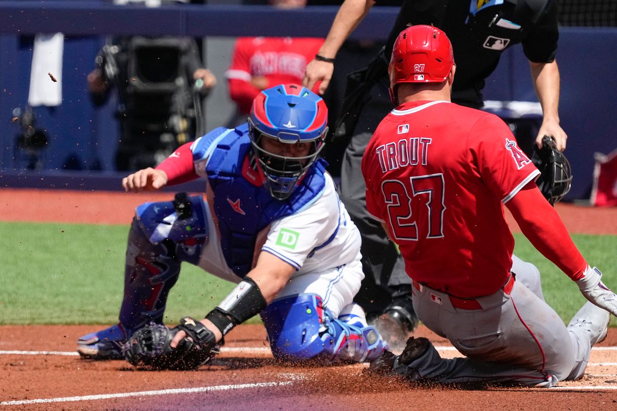 Toronto Blue Jays catcher Alejandro Kirk (30) tags out Los Angeles Angels designated hitter Mike Trout (27) at home plate during the first inning at Rogers Centre. Toronto Blue Jays catcher Alejandro Kirk (30) tags out Los Angeles Angels designated hitter Mike Trout (27) at home plate during the first inning at Rogers Centre.