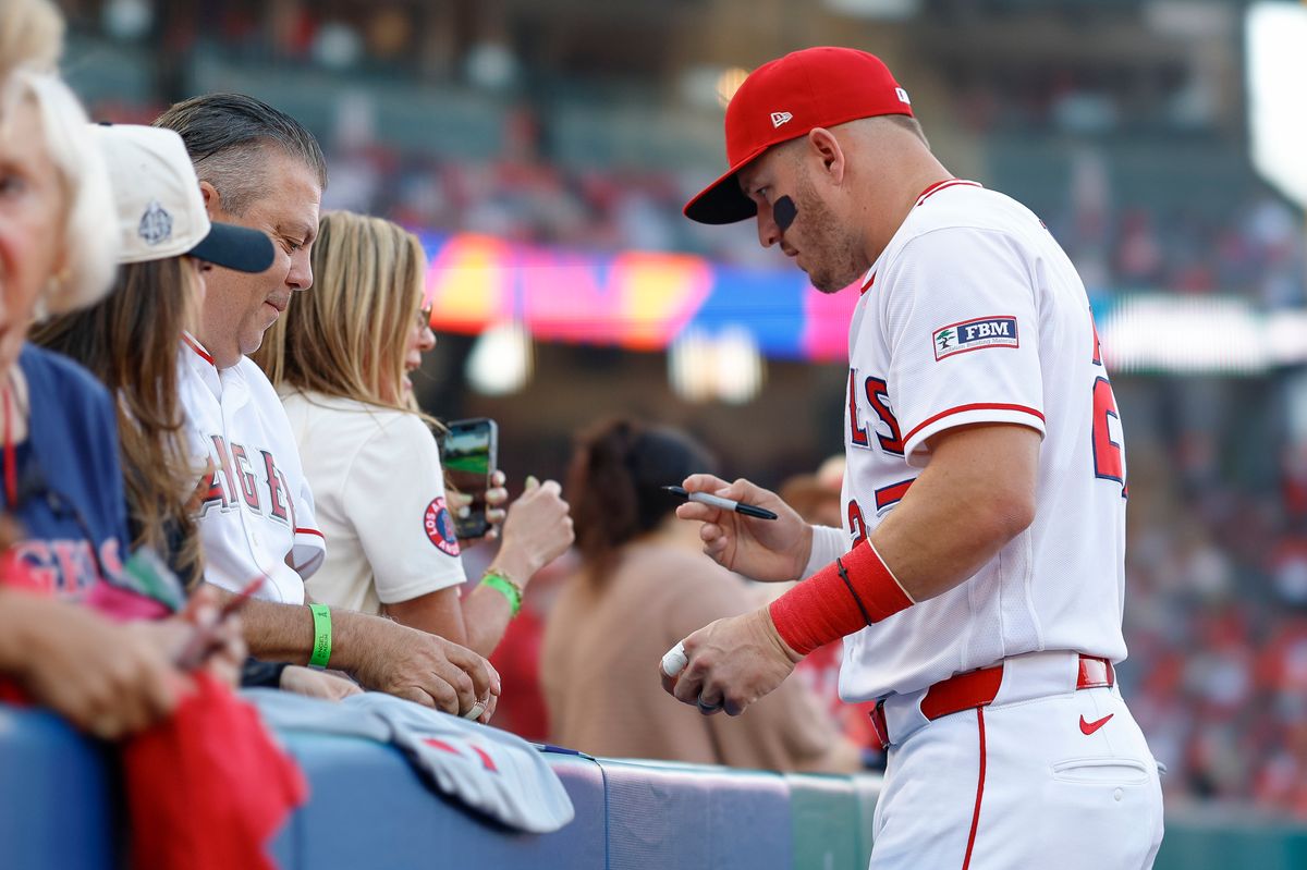 Mike Trout #27 of the Los Angeles Angels signs an autograph for a fan prior to a game against the New York Mets at Angel Stadium on May 1, 2026, in Anaheim, California.