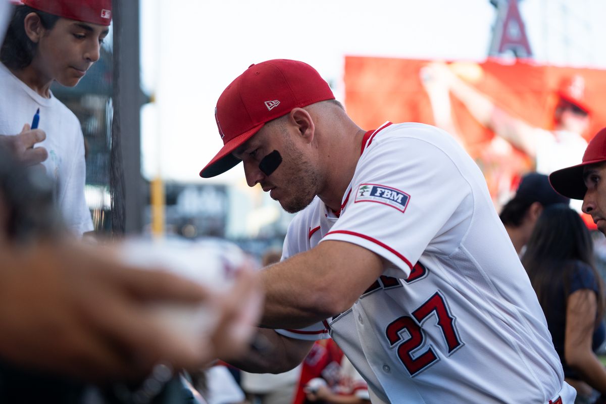 Los Angeles Angels center fielder Mike Trout (27) signs autographs for fans at field level during an MLB game against the Tampa Bay Rays at Angel Stadium on June 13, 2026, in Anaheim, California.
