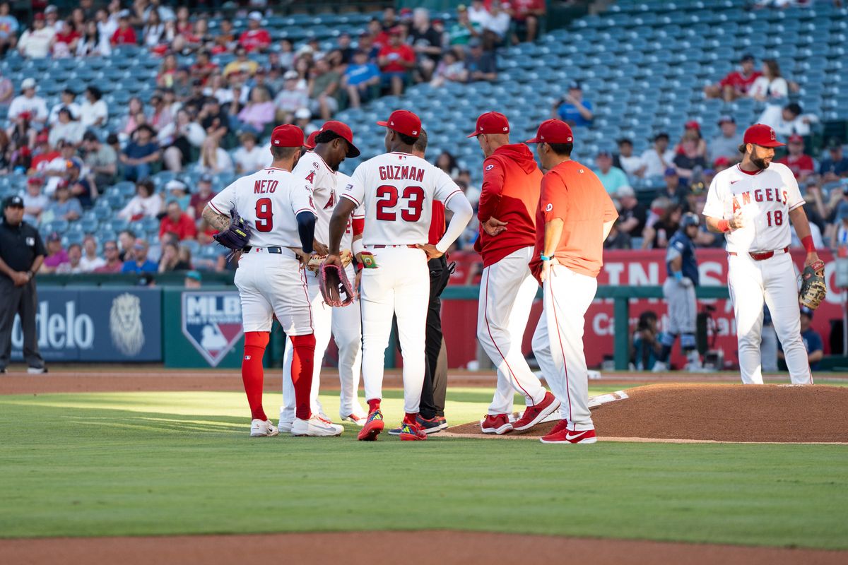 Los Angeles Angels in field and coaches come together to check on the pitcher after getting hit during an MLB game against the Tampa Bay Rays at Angel Stadium on June 13, 2026, in Anaheim, California.