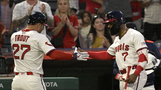 Jul 9, 2025; Anaheim, California, USA; Los Angeles Angels designated hitter Mike Trout (27) is congratulated at the dugout by center fielder Jo Adell (7) after a solo home run in the fifth inning against the Texas Rangers at Angel Stadium. Mandatory Credit: Jayne Kamin-Oncea-Imagn Images