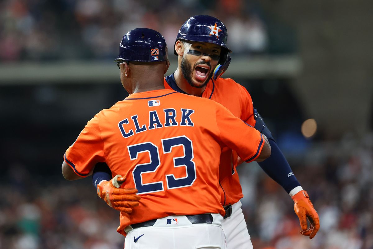 Houston Astros first base coach Dave Clark (23) celebrates third baseman Carlos Correa (1) RBI single against the Los Angeles Angels in the seventh inning at Daikin Park. 