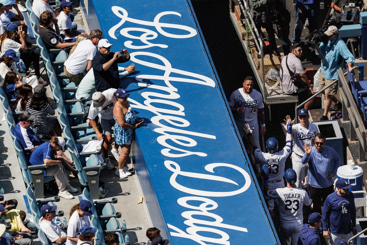 Los Angeles Dodgers third baseman Max Muncy (13) celebrates in dugout while fans takes photos of him during an MLB game against the Atlanta Braves on May 10, 2026 in Los Angeles, CA.