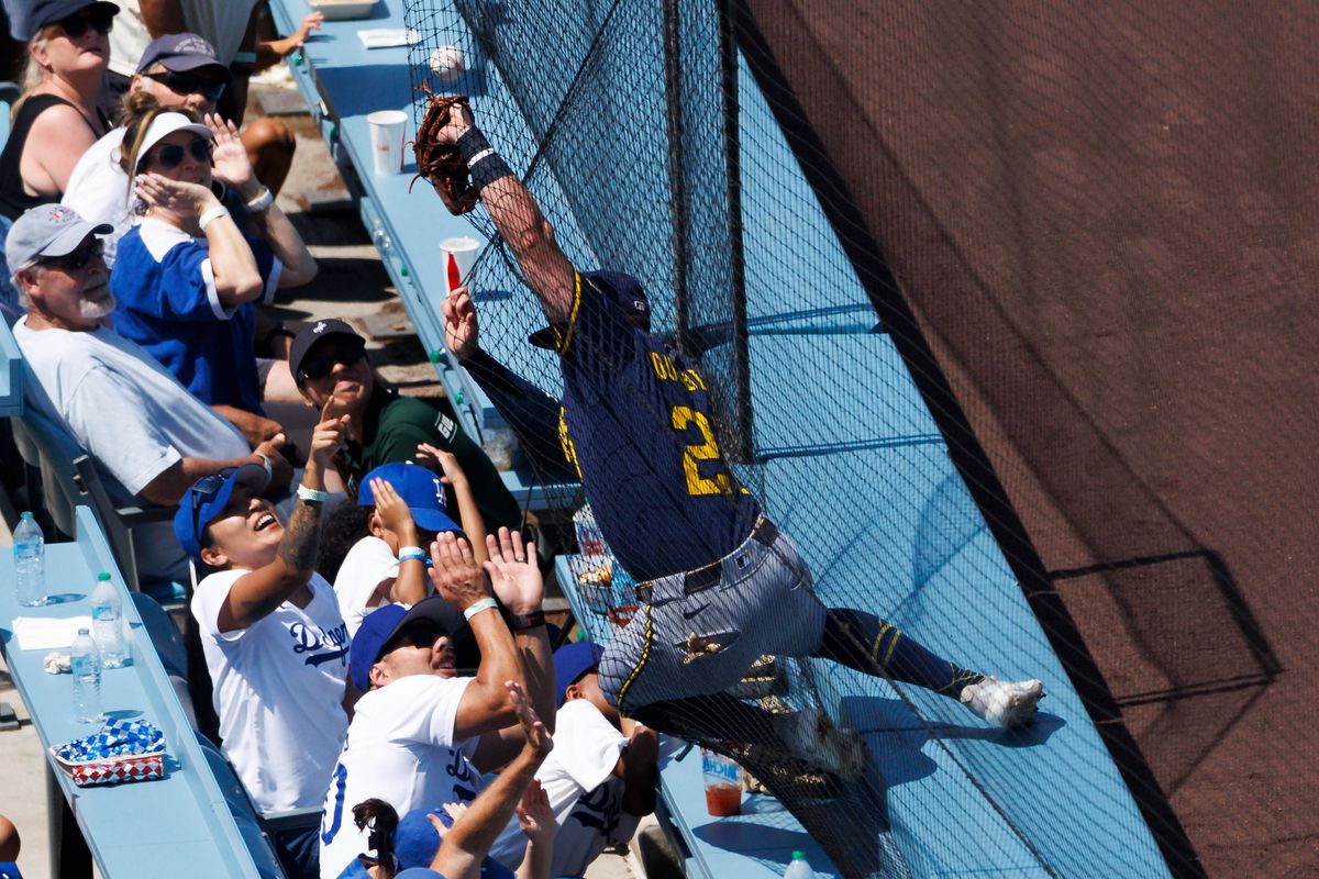 Caleb Durbin #21 of the Milwaukee Brewers attempts to catch a fly ball in foul territory during the game against the Los Angeles Dodgers at Dodger Stadium on July 20, 2025 in Los Angeles, California.