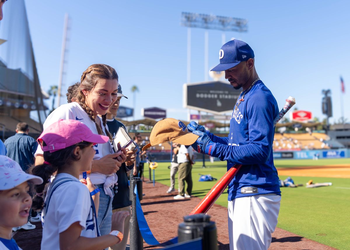 Los Angeles Dodgers infielder, Mookie Betts 50, autographs Dodgers merchandise before an MLB baseball game against the Cincinnati Reds on August 26, 2025 in Los Angeles, CA.