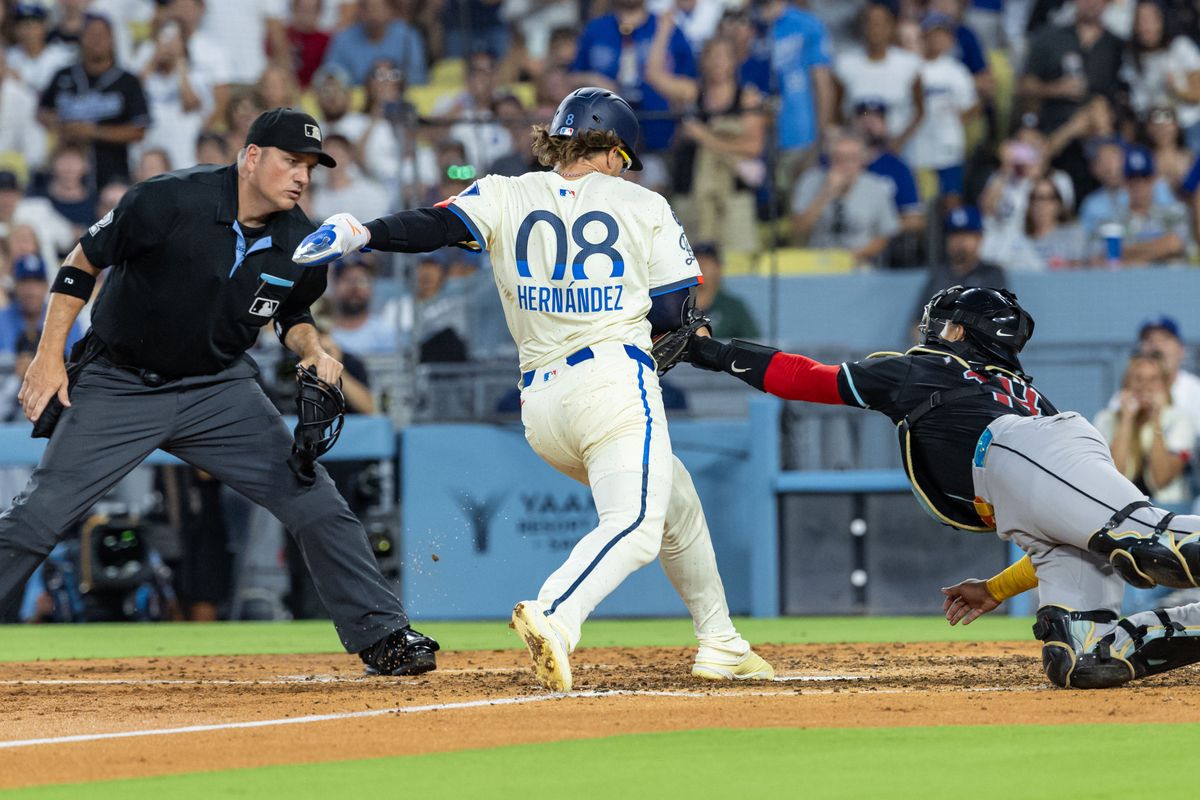Enrique Hernández #8 of the Los Angeles Dodgers gets tagged out at home by Gabriel Moreno #14 of the Arizona Diamondbacks during an MLB game at Dodger Stadium on August 30, 2025 in Los Angeles, California.