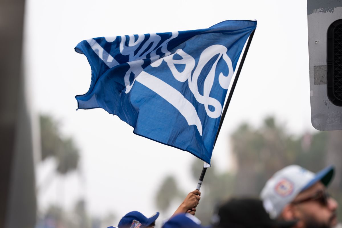 LOS ANGELES, Calif. — Nov. 3, 2025 — A Dodgers flag waves above the crowd during the team’s championship parade on Monday. LOS ANGELES, Calif. — Nov. 3, 2025 — A Dodgers flag waves above the crowd during the team’s championship parade on Monday.