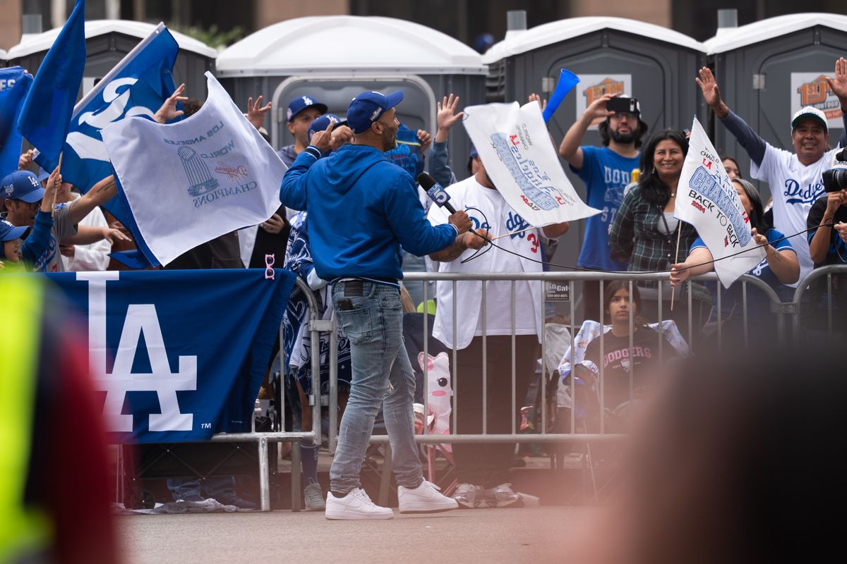 LOS ANGELES, Calif. — Nov. 3, 2025 — A broadcast journalist runs past fans while reporting during the Dodgers championship parade on Monday. LOS ANGELES, Calif. — Nov. 3, 2025 — A broadcast journalist runs past fans while reporting during the Dodgers championship parade on Monday.