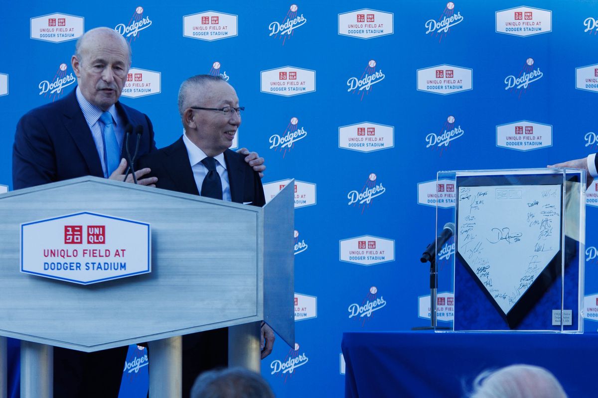 UNIQLO founder Tadashi Janai is gifted a home plate signed by the Los Angeles Dodgers' players during a UNIQLO partnership press conference on March 25, 2026 in Los Angeles, California.