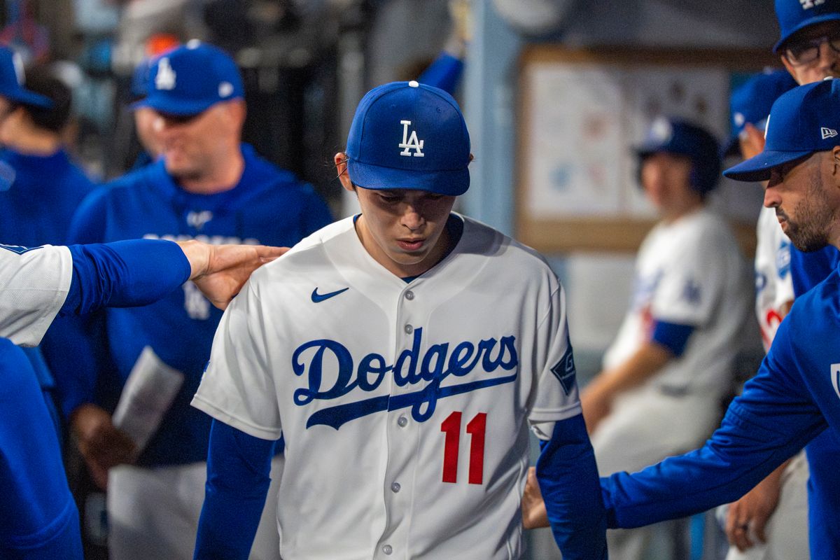 Los Angeles Dodgers pitcher Roki Sasaki (11) returns to the dugout sullenly after being relieved during an MLB baseball game against the Baltimore Orioles on June 19th, 2026 in Los Angeles, CA.