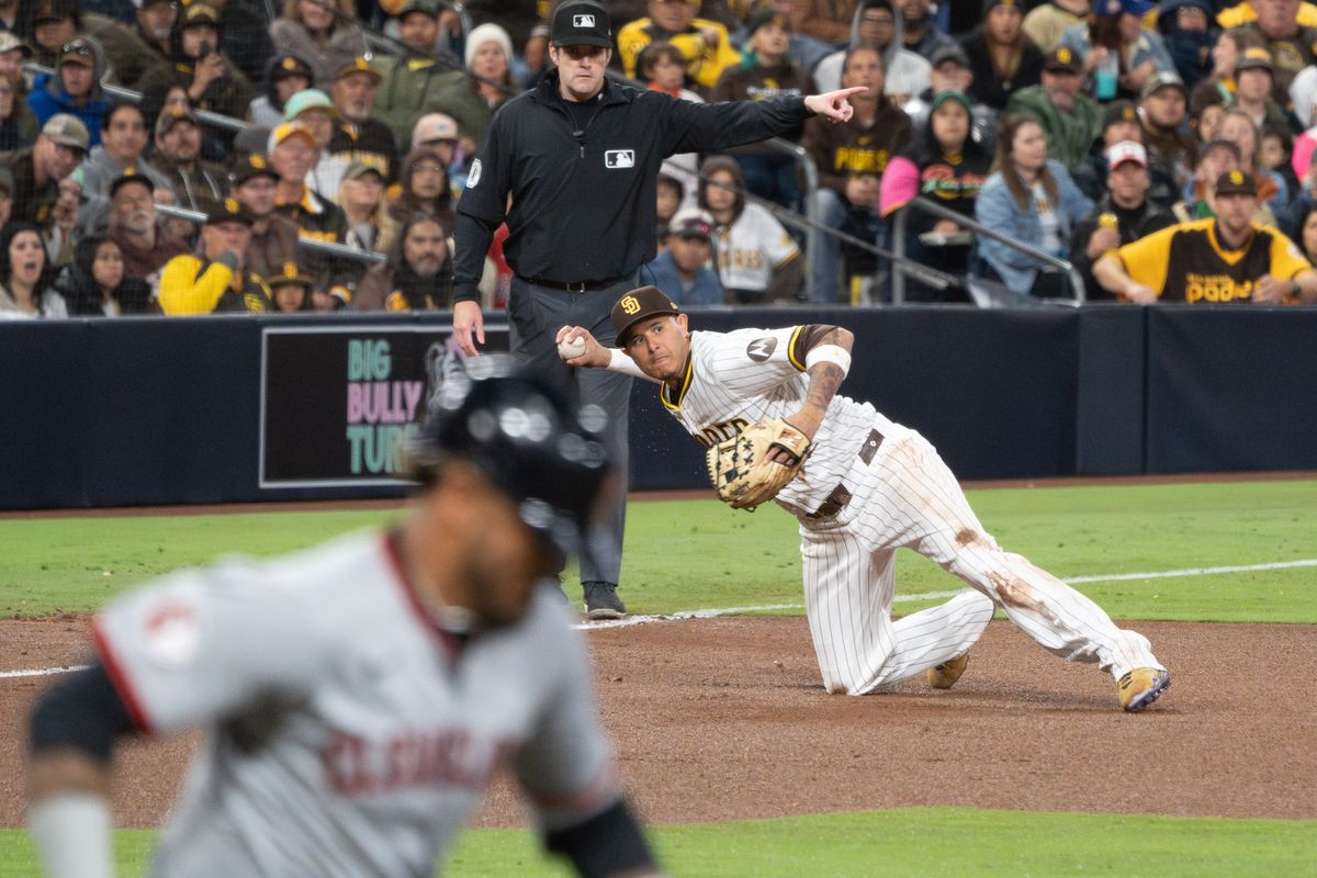 San Diego Padres Third Baseman, Manny Machado (13), attempts to throw the runner out from his knees during an MLB Baseball game against the Cleveland Guardians at Petco Park in San Diego, CA, on March 31, 2025. San Diego Padres Third Baseman, Manny Machado (13), attempts to throw the runner out from his knees during an MLB Baseball game against the Cleveland Guardians at Petco Park in San Diego, CA, on March 31, 2025.