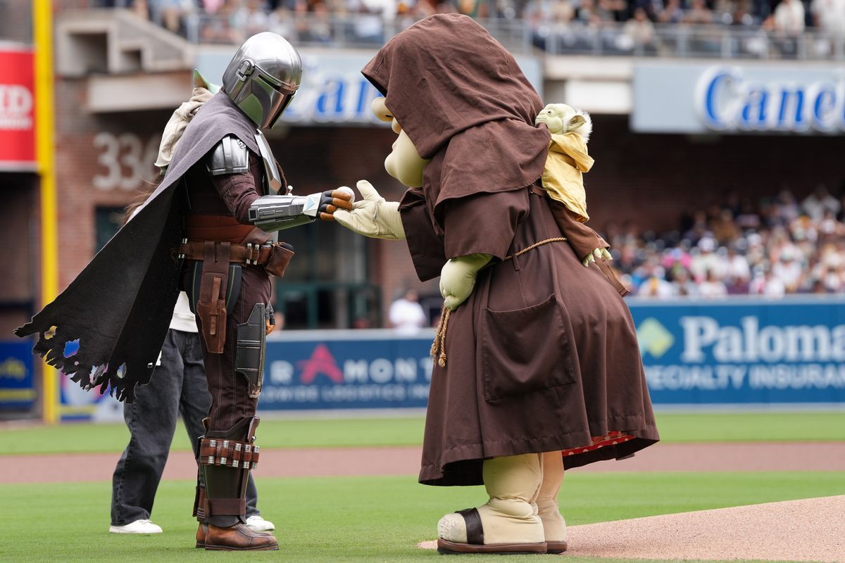 Mandalorian hands off baseball to Padres mascot before an MLB baseball game against the Athletics, Sunday May 24, 2026 in San Diego, California. Mandalorian hands off baseball to Padres mascot before an MLB baseball game against the Athletics, Sunday May 24, 2026 in San Diego, California.