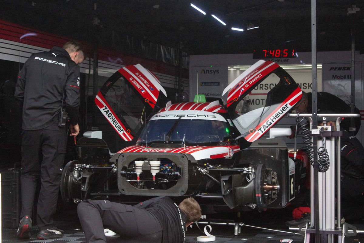 Members of the Porsche race team prepare a car before the Friday practice sessions at the 2025 Acura Grand Prix of Long Beach. 