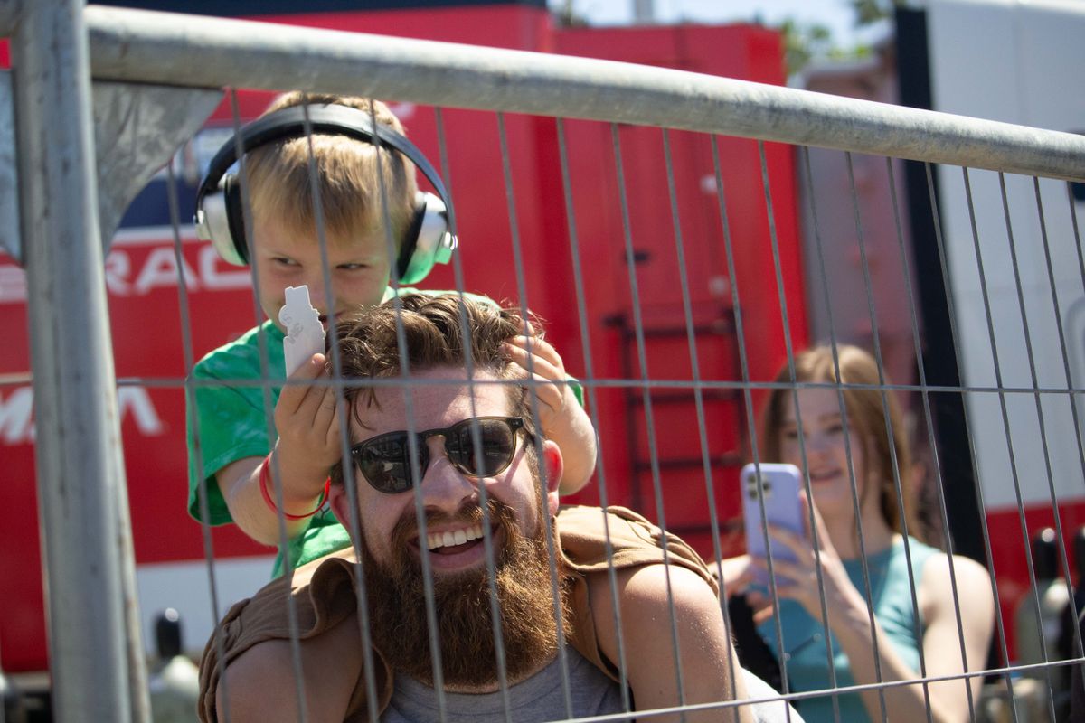 A young fan wearing ear protection sits on his father's shoulders at the Friday practice sessions at the 2025 Acura Grand Prix of Long Beach. 