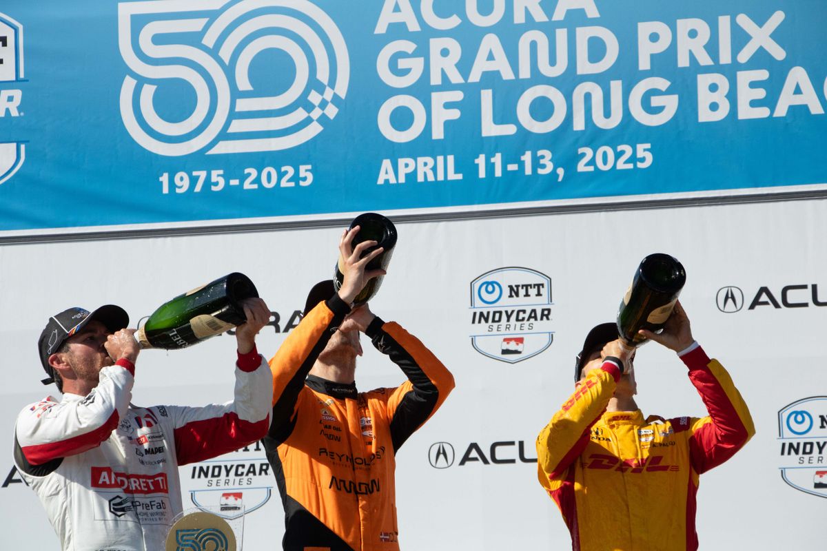 Kyle Kirkwood (center), Alex Palou (left) and Christian Lungaard (right) celebrate with champagne after the NTT IndyCar Series Grand Prix at the 2025 Acura Grand Prix of Long Beach. 