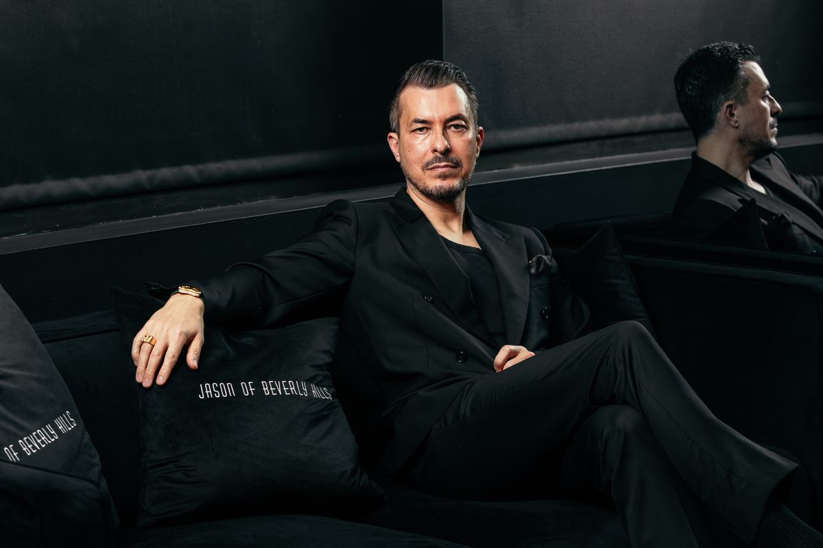 Jason Arasheben poses for a portrait alongside pillows bearing the Jason of Beverly Hills name. Jason Arasheben poses for a portrait alongside pillows bearing the Jason of Beverly Hills name.