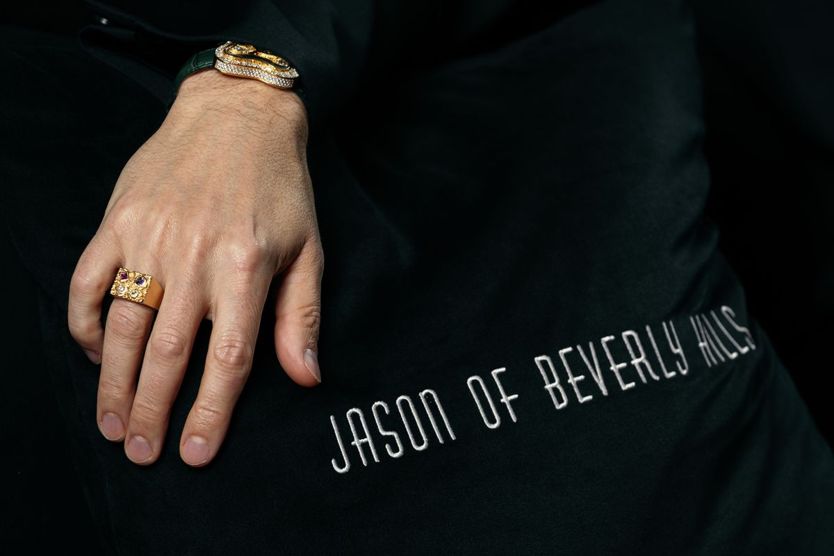 Jason Arasheben poses for a portrait alongside pillows bearing the Jason of Beverly Hills name. Jason Arasheben poses for a portrait alongside pillows bearing the Jason of Beverly Hills name.