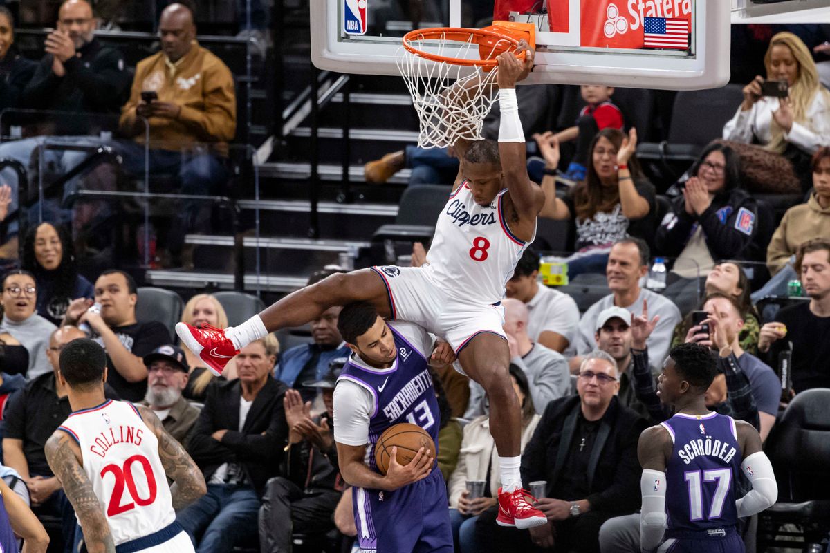 Kris Dunn #8 of the LA Clippers dunks the ball over Keegan Murray #13 of the Sacramento Kings during an NBA basketball game, Tuesday December 30, 2025 in Inglewood, Calif.