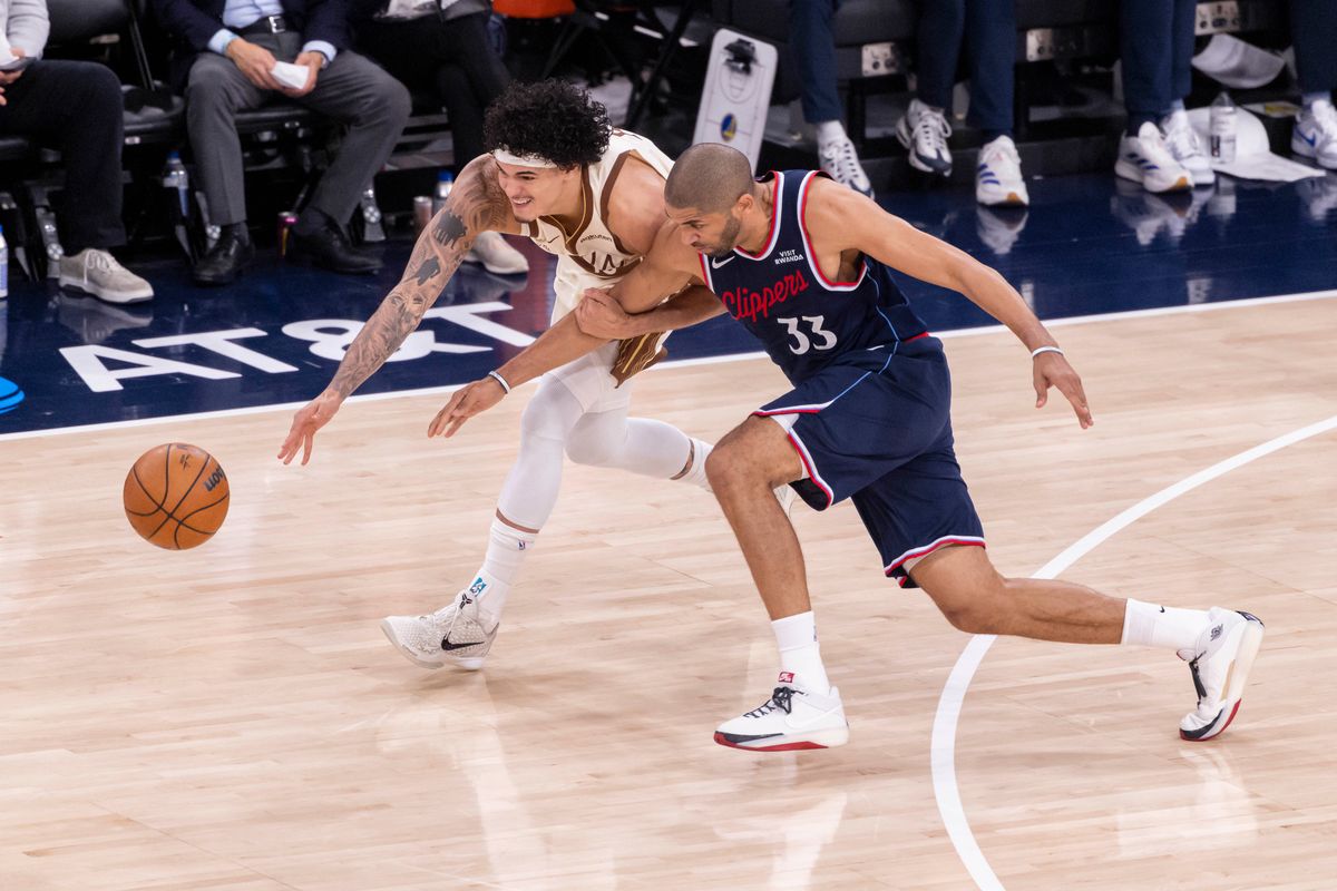 Gui Santos #15 of the Golden State Warriors and Nicolas Batum #33 of the LA Clippers reach for a loose ball during an NBA basketball game, Monday January 5, 2026 in Inglewood, Calif.