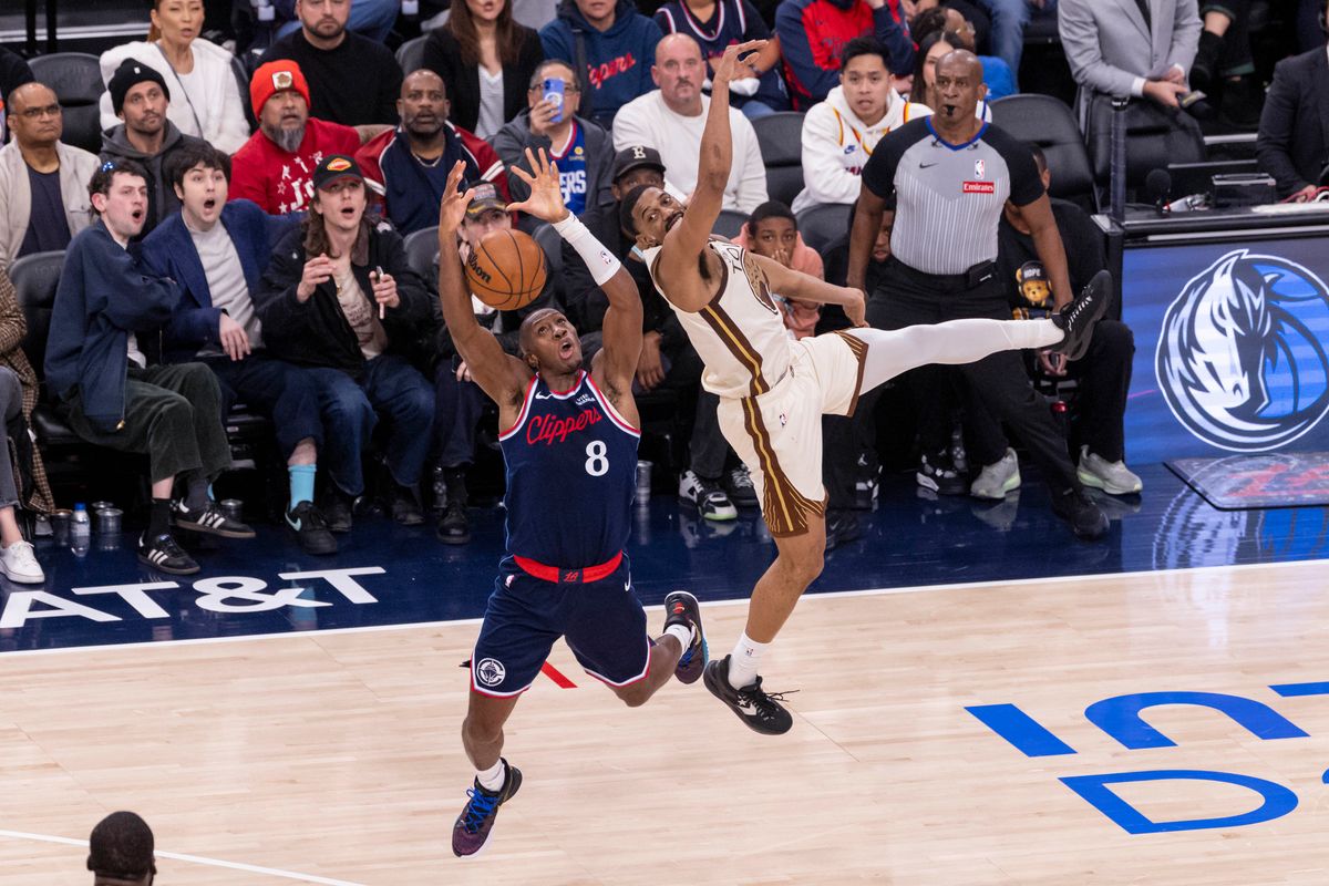 Kris Dunn #8 of the LA Clippers and De'Anthony Melton #8 of the Golden State Warriors reach for a loose ball during an NBA basketball game, Monday January 5, 2026 in Inglewood, Calif.