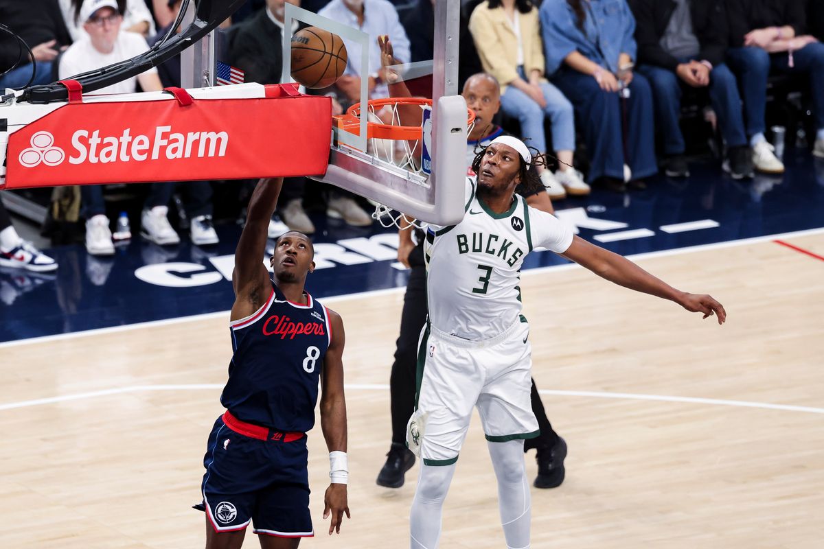 Kris Dunn #8 of the LA Clippers lays the ball up as Myles Turner #3 of the Milwaukee Bucks reaches to block it during an NBA basketball game, 2026 in Inglewood, Calif.