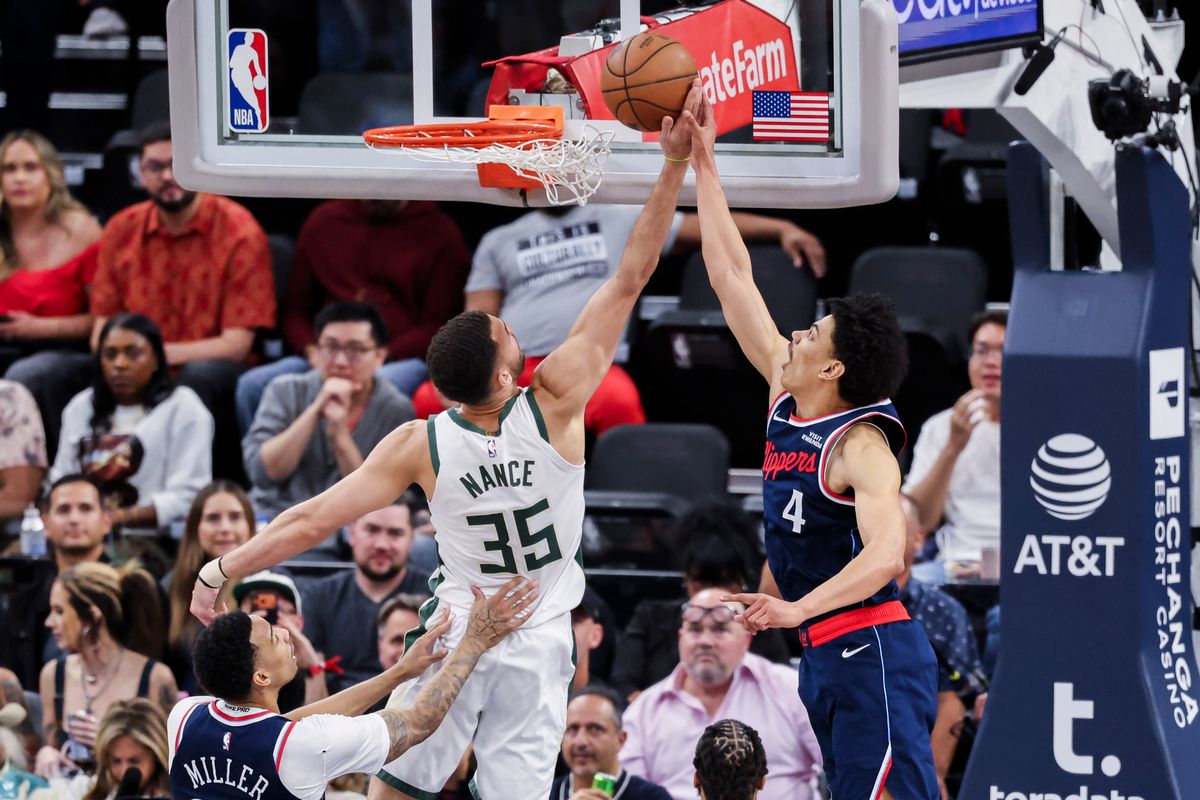 Pete Nance #35 of the Milwaukee Bucks and Kobe Sanders #4 of the LA Clippers reach for the ball during an NBA basketball game, 2026 in Inglewood, Calif.