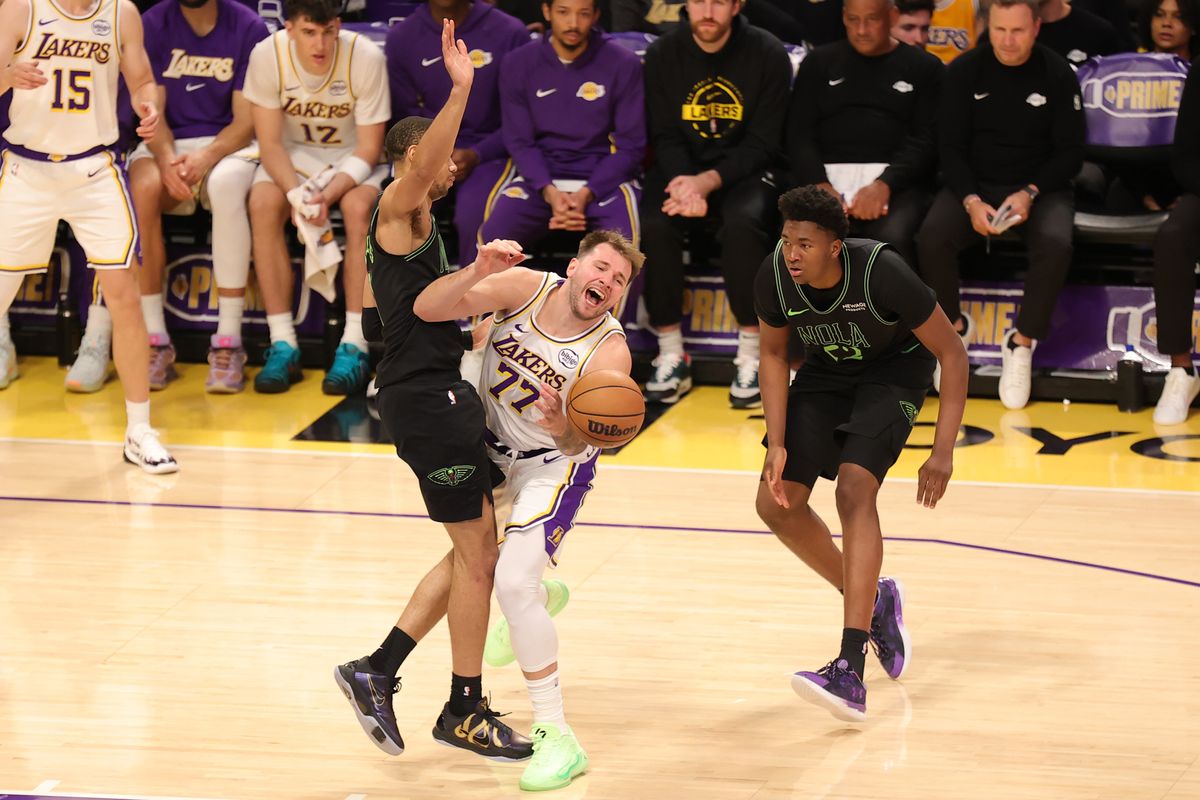 #77 PG Luka Doncic of the Los Angeles Lakers collides with a defender during an NBA game against the New Orleans Pelicans on November 30, 2025 in Los Angeles, CA.