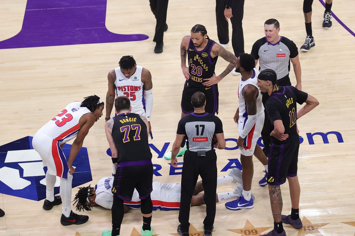 Multiple Los Angeles Lakers and Detroit Pistons players look as #5 F Ronald Holland II of the Detroit Pistons sustains an injury during an NBA game on December 30, 2025 in Los Angeles, CA.