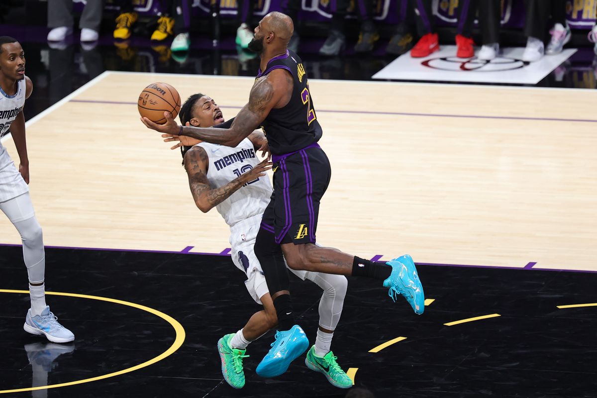 #23 SF LeBron James of the Los Angeles Lakers charges into #12 PG Ja Morant of the Memphis Grizzlies during an NBA game on January 2, 2026 in Los Angeles, CA.