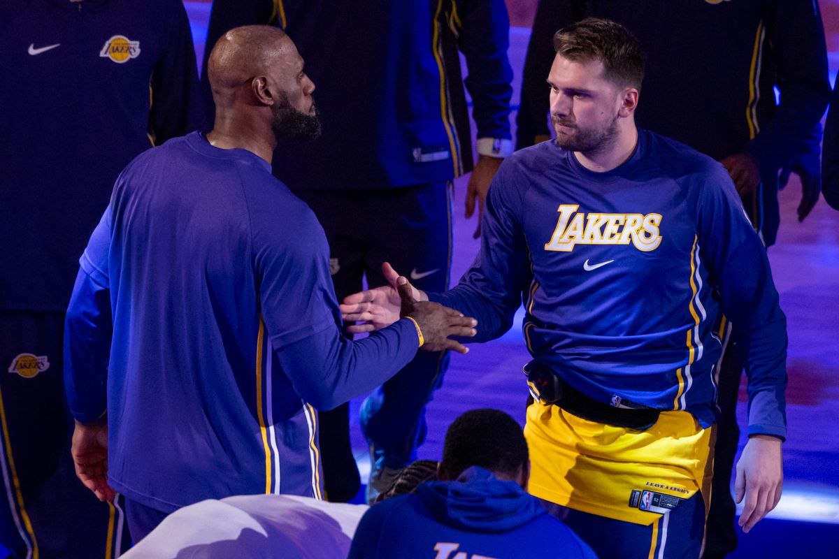LeBron James #23 and Luka Doncic #77 of the Los Angeles Lakers high five during start lineup introductions before an NBA basketball game against the Charlotte Hornets, Thursday January 15, 2026 in Inglewood, Calif.