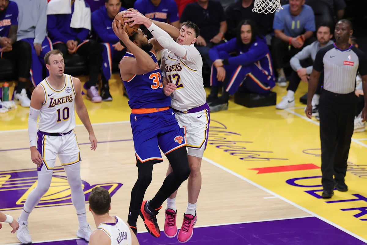 Los Angeles Lakers forward Jake LaRavia (12) defends against New York Knicks center Karl Anthony Townes (32) during an NBA game on March 8, 2026 in Los Angeles, CA.