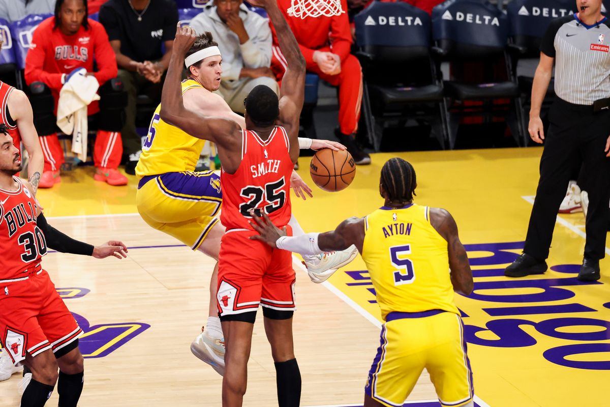 Austin Reaves #15 of the Los Angeles Lakers passes the ball around Jalen Smith #25 of the Chicago Bulls during an NBA basketball game, Thursday March 12, 2026 in Los Angeles, Calif.