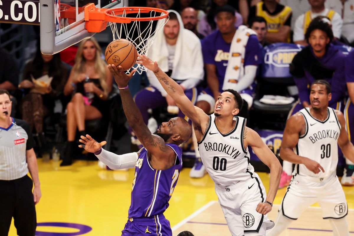 LeBron James #23 of the Los Angeles Lakers lays the ball up past a reaching Josh Minott #00 of the Brooklyn Nets during an NBA basketball game, Friday March 27, 2026 in Los Angeles, Calif.