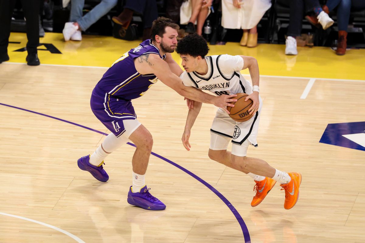 Luka Doncic #77 of the Los Angeles Lakers pokes the ball away from Nolan Traore #88 of the Brooklyn Nets during an NBA basketball game, Friday March 27, 2026 in Los Angeles, Calif.