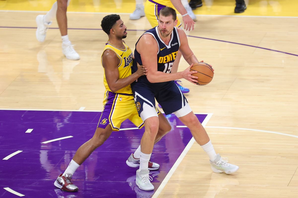 Los Angeles Lakers G Quentin Grimes (5) defends against Denver Nuggets C Nikola Jokic (15) during an NBA basketball game, Friday October 16, 2026 in Los Angeles, Calif.