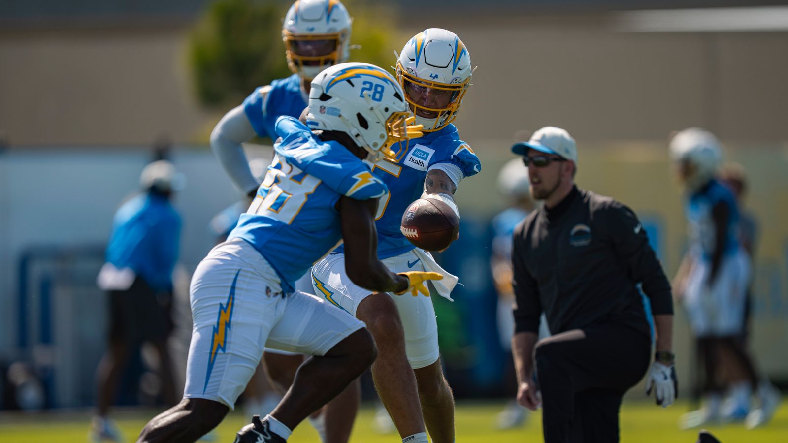 Los Angeles Chargers quarterback Trey Lance (5) handing the ball off to running back Kimani Vidal (28) during Chargers training camp at the Bolt on Wednesday, July 29th in El Segundo, CA. Los Angeles Chargers quarterback Trey Lance (5) handing the ball off to running back Kimani Vidal (28) during Chargers training camp at the Bolt on Wednesday, July 29th in El Segundo, CA.