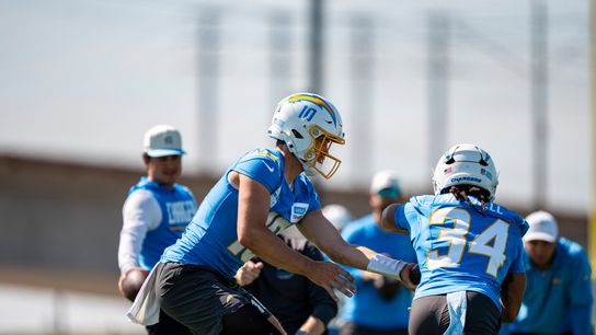 Los Angeles Chargers quarterback Justin Herbert (10) handing the ball off to running back Keaton Mitchell (34) during Chargers training camp at The Bolt on Friday, July 31th in El Segundo, CA. Los Angeles Chargers quarterback Justin Herbert (10) handing the ball off to running back Keaton Mitchell (34) during Chargers training camp at The Bolt on Friday, July 31th in El Segundo, CA.